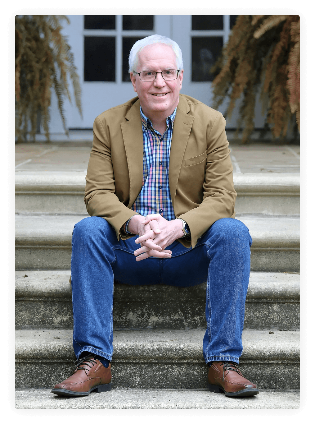 Person in glasses seated on stone stairs