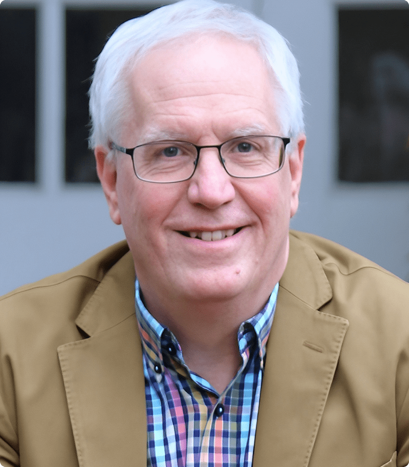 Smiling man with white hair and glasses